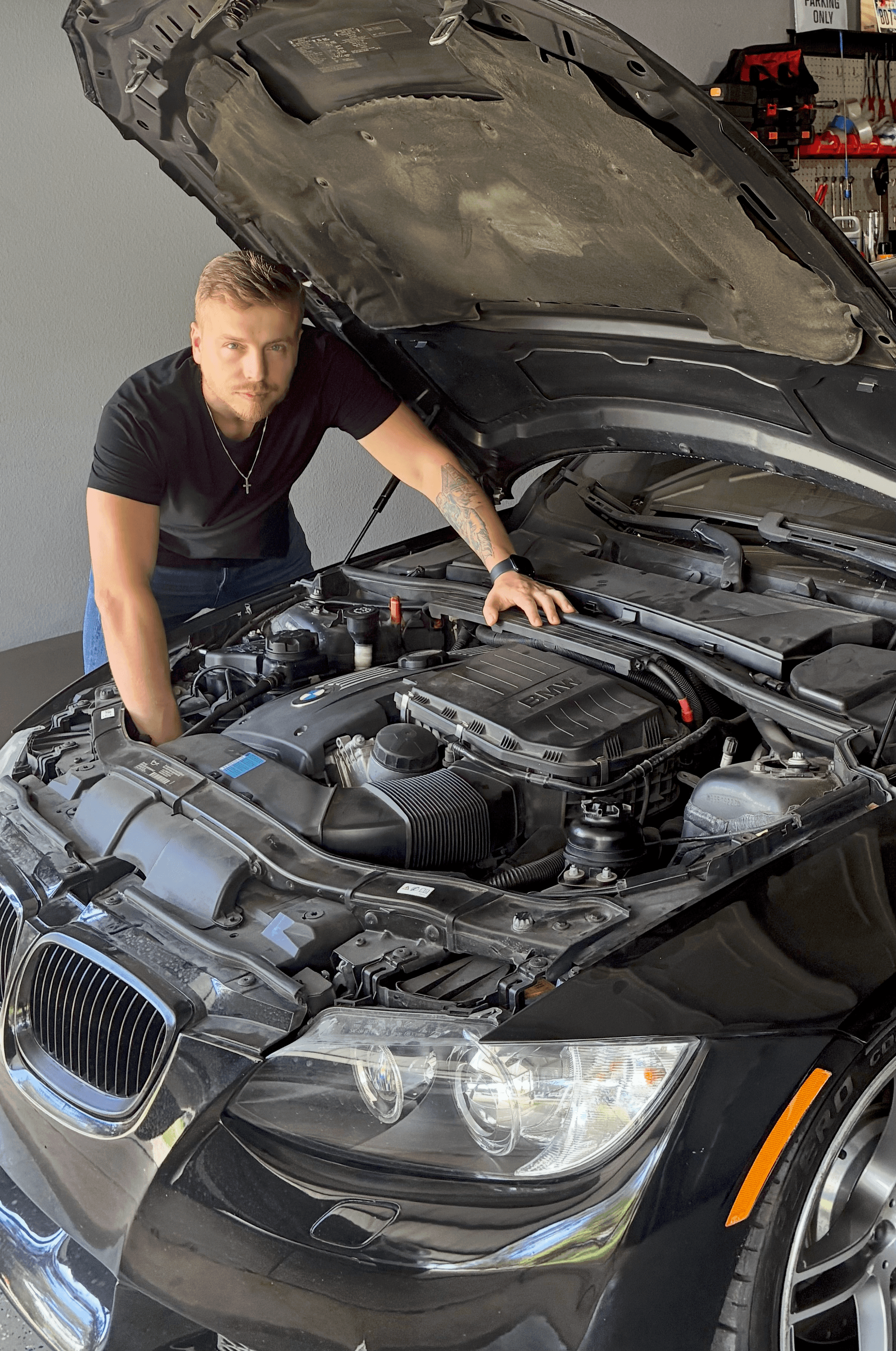 Anton working under the hood of a BMW in a repair shop